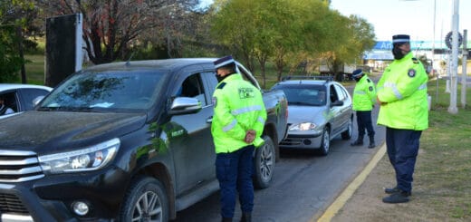 alt="a la izquierda, dos policías controlan dos automoviles, detrás de ellos un compañero los observa"