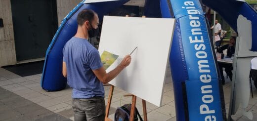 alt="artista plástico pinta un cuadro en un lienzo, ante un gazebo desmontable ubicado en la peatonal de concordia"