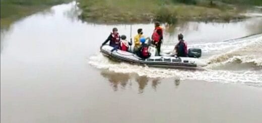 alt="en la imagen, un bote semirrigido, con cinco integrantes del grupo de rescate, navega por el arroyo Yeruá"
