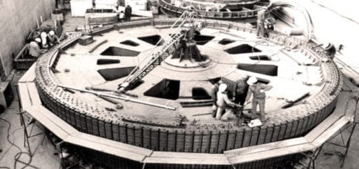 alt="obreros parados sobre una de las turbinas de salto grande"