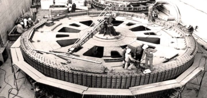 alt="obreros parados sobre una de las turbinas de salto grande"