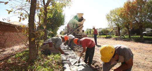 alt="en la imagen, varios obreros construyen un cordón cuneta, detrás un camión mezclador"