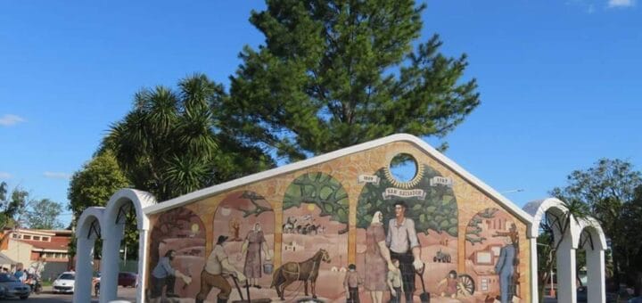 alt="en la imagen se ve un mural que cuenta la historia de San Salvador"