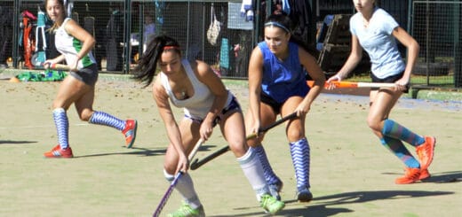 alt="en esta fotografía puede verse a varias jugadoras de hockey sobre césped disputando un cotejo"