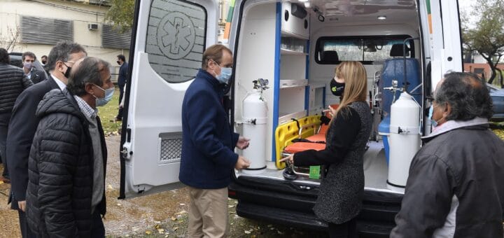 alt="en la imagen puede verse a varias personas con una ambulancia"