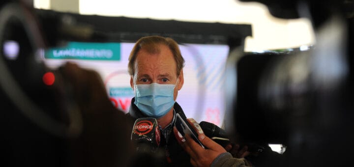 alt="un hombre con barbijo habla ante los micrófonos de medios de comunicación"