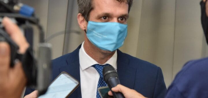 alt="en la imagen, un hombre con barbijo realiza declaraciones ante micrófonos y grabadores"