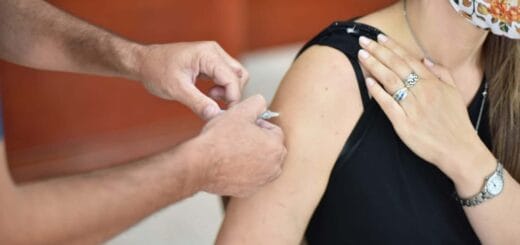 alt="en la foto puede verse como aplican una inyección en el brazo de una mujer"