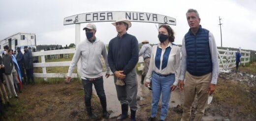 alt="en la fotografía pueden verse a cuatro personas, tres hombres y una mujer, en la entada de un establecimiento rural que tiene un cartel que dice Casa Nueva"