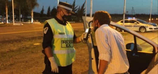 alt="en la fotografía, un policía le realiza un control de alcoholemia a un conductor al costado de una ruta"