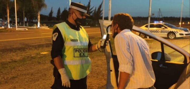 alt="en la fotografía, un policía le realiza un control de alcoholemia a un conductor al costado de una ruta"