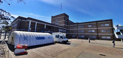 alt="en la imagen puede verse una carpa sanitaria, detrás parte del edificio del hospital Masvernat"