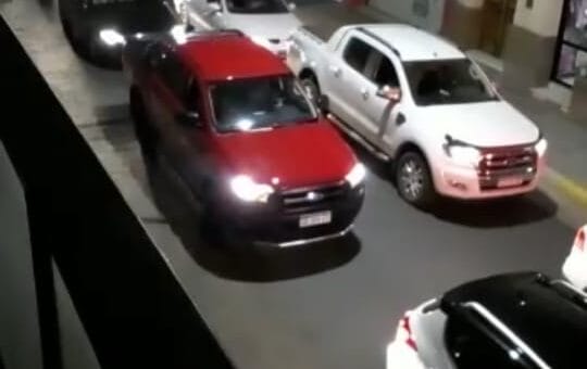 alt="varios automóviles en doble fila en una calle"