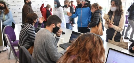 alt="en la fotografía puede verse a varias personas registrándose para recibir la vacuna contra el coronavirus, las atienden voluntarios que los inscriben en computadoras"