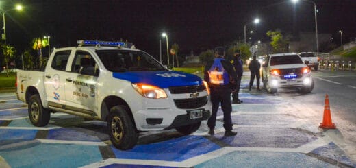 alt="en la imagen, dos móviles policiales y algunos policías alrededor"