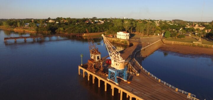 alt="en la imagen puede verse dos grúas y un muelle del puerto de salto"