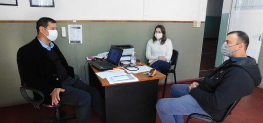 alt="puede verse dos hombres y una mujer alrededor de una mesa"