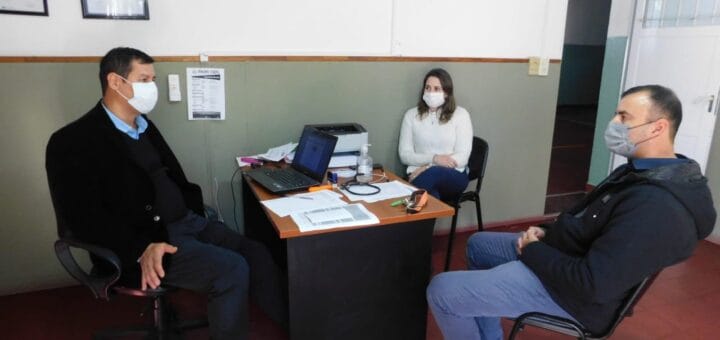 alt="puede verse dos hombres y una mujer alrededor de una mesa"