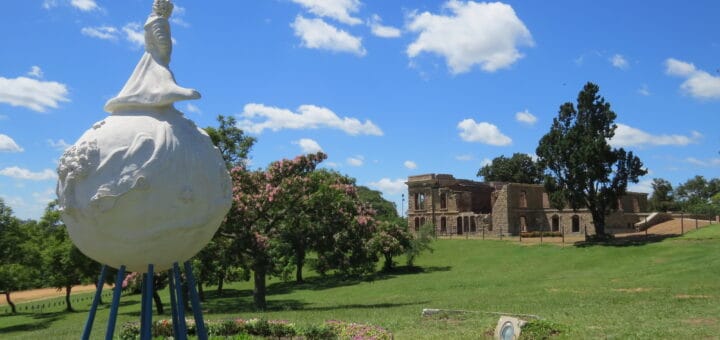 alt="en la imagen puede verse un monumento a el principito y una casa en ruinas"