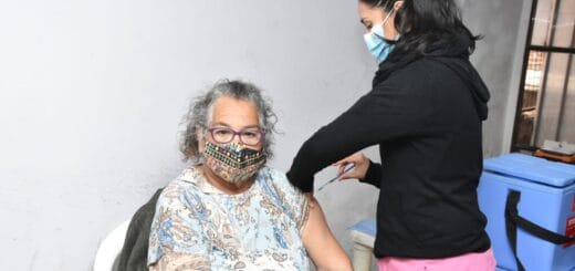 alt="en la imagen, una mujer vacuna a otra"