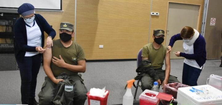 alt="en la fotografía, dos efectivos de la gendarmería son vacunados"