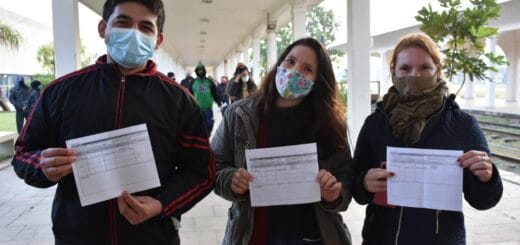 alt="en la imagen puede verse a tres de los vacunados exhibiendo sus certificados"