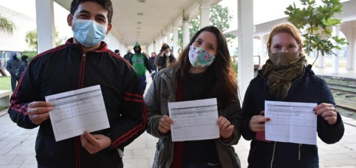 alt="en la imagen puede verse a tres de los vacunados exhibiendo sus certificados"