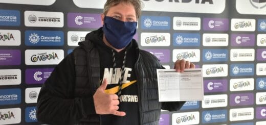 alt_="en la imagen puede verse a un hombre que exhibe su certificado de vacunación"