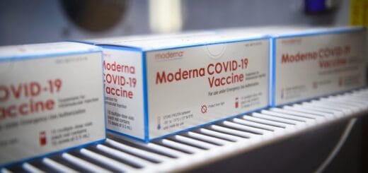 alt="en la imagen pueden verse cajas de vacunas de la empresa Moderna"