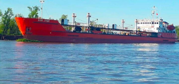 alt="en la imagen puede verse al buque tanquero Don Juan en un río, detrás se observa vegetación de la costa"