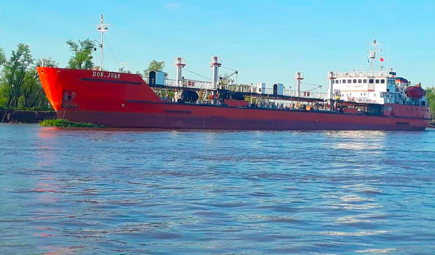 alt="en la imagen puede verse al buque tanquero Don Juan en un río, detrás se observa vegetación de la costa"