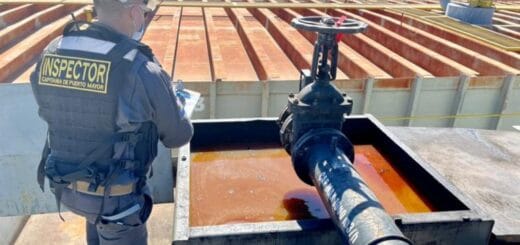 alt="en la imagen puede verse a un funcionario de la armada boliviana inspeccionando una barcaza tanque"