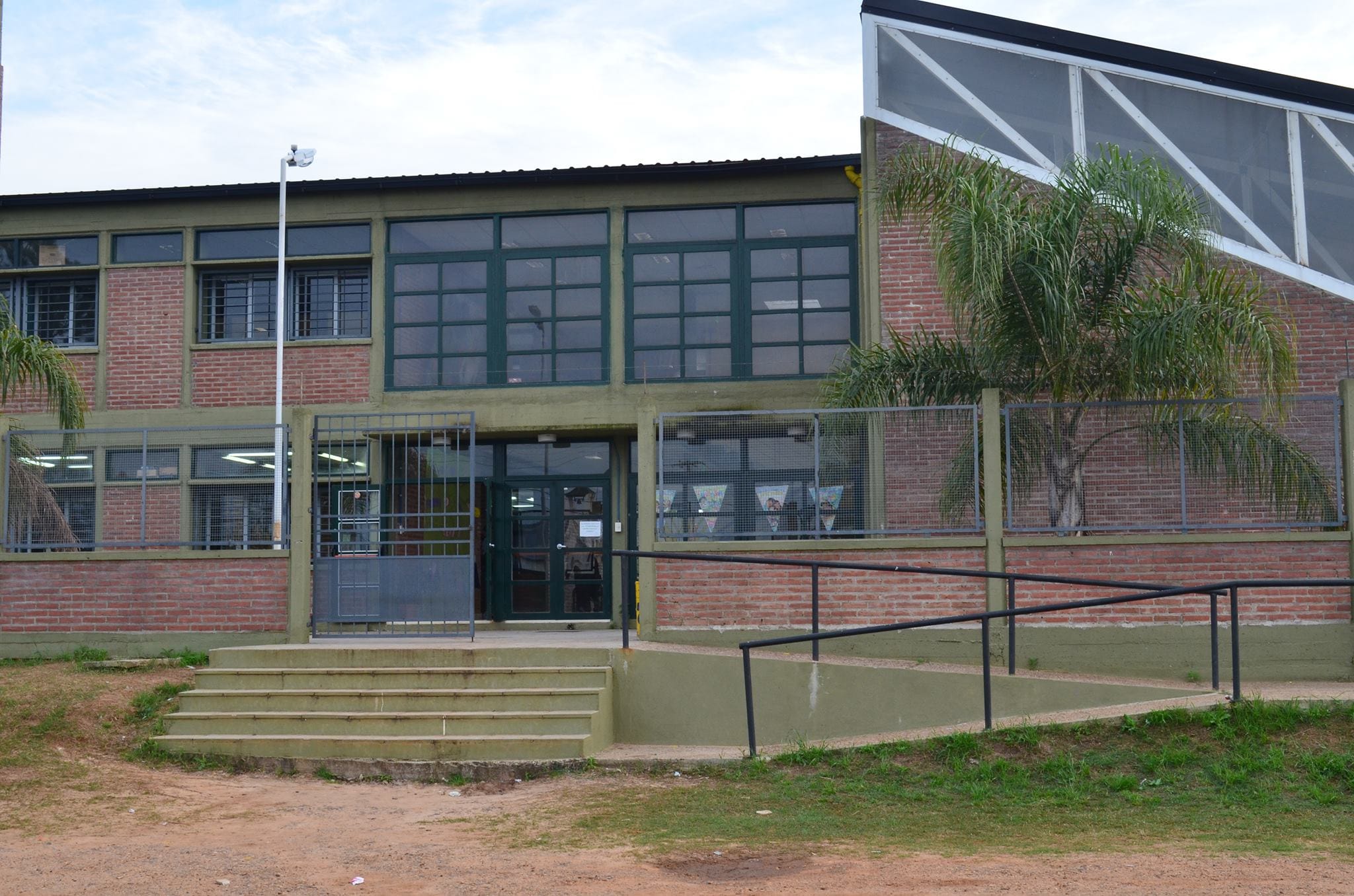 alt="en la imagen puede verse el frente de una escuela"