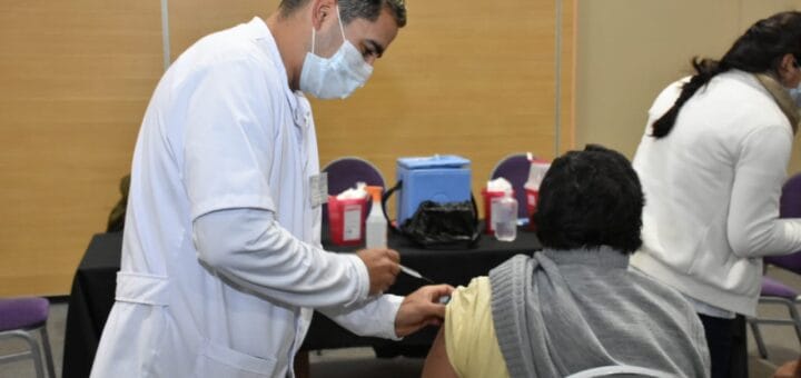 alt="un enfermero vacuna a un hombre"