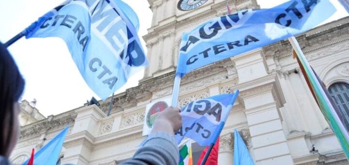 alt="en la imagen pueden verse banderas de AGMER exhibidas frente a la Casa de Gobierno de Entre Ríos"