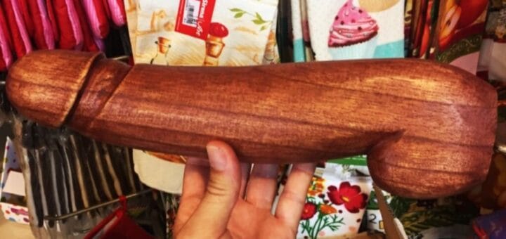 alt="en la imagen puede verse a un pene de madera sostenido por una mano"
