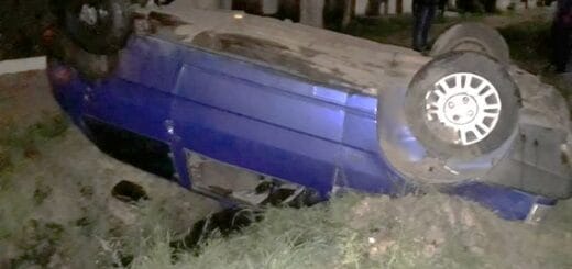 alt="en la imagen puede verse un auto volcado dentro de una zanja"