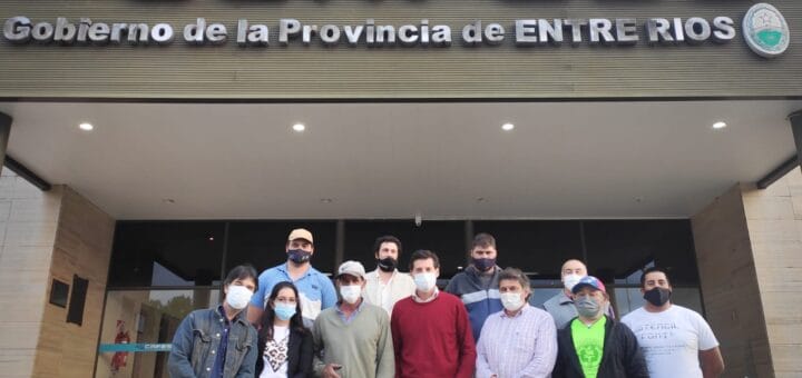 alt="en la imagen puede verse a varias personas en el frente de la sede de la CAFESG en Concordia"