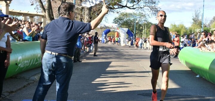 alt="Juan Ignacio Segovia llega a la meta y recibe el banderazo del intendente Francolini"