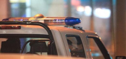 alt="en la imagen puede verse parcialmente una patrulla policial con las luces en el techo de la cabina"