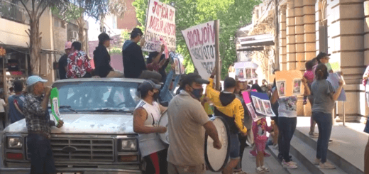alt="personas manifestándose en la calle, algunos con carteles y pancartas, otros con bombos y tambores"