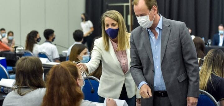 alt="en la imagen puede verse al gobernador y a la vicegobernadora saludando a dos jóvenes del senado juvenil, detrás de ellos hay varios jóvenes sentados, una adulta de pie y un adulto sentado"