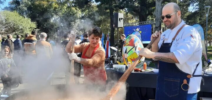 alt="un cocinero y una cocinera cocinan una porción gigante de pollo al disco"