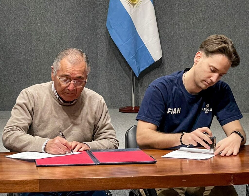 alt="firma del convenio entre el presidente de CAFESG, Carlos Cecco, y el prresidente de Ángeles Callejeros, Franco Bollini"