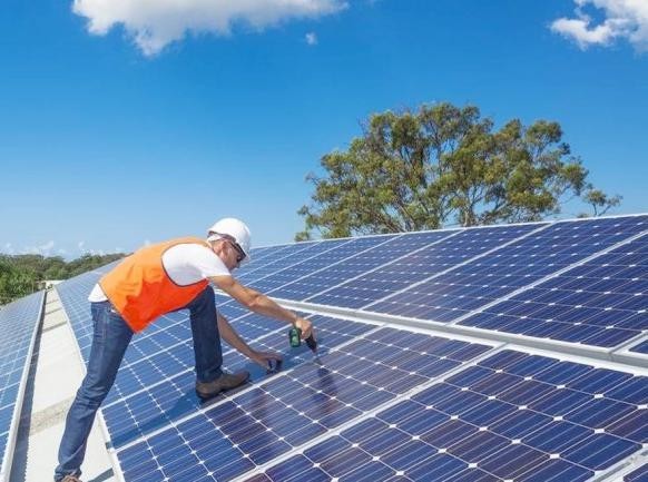 alt="un hombre trabaja con unos paneles de energía solar, uno de los sectores en que innova la Cooperativa Eléctrica de Concordia"
