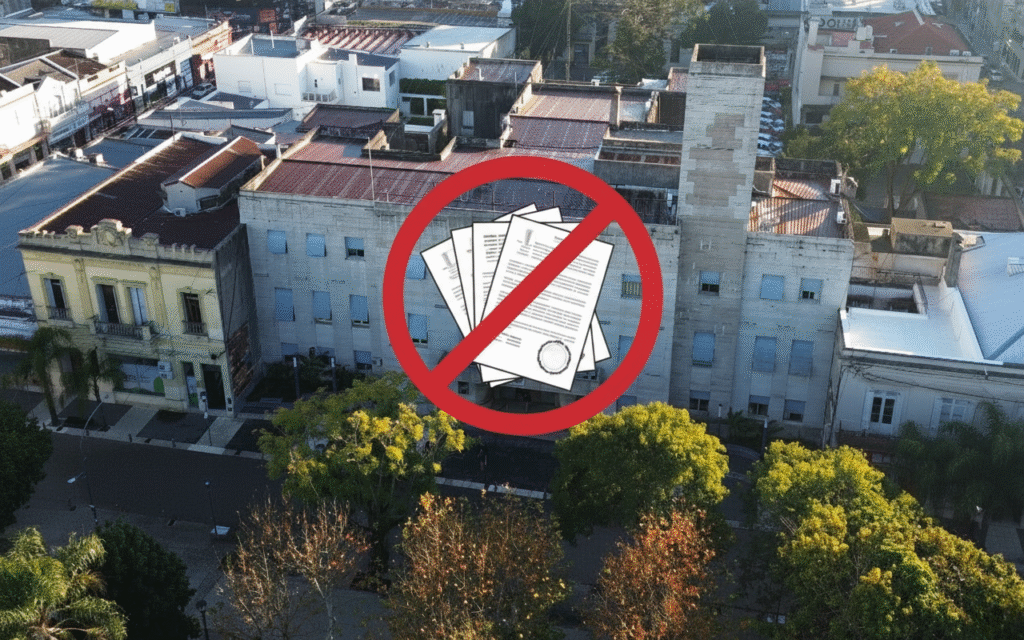 alt="el edificio de la municipalidad de Concordia y un logo de prohibido en alusión a los títulos falsos presentados por empleados del municipio"