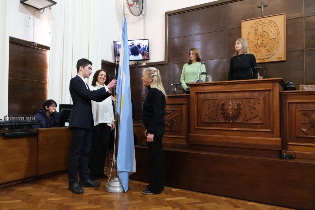 alt="Alberto Müller Williman e integrantes de la Fundación Cuidados Paliativos izan la Bandera Nacional al inicio de una sesión del Concejo Deliberante que se destacó por el debate y los reconocimientos"