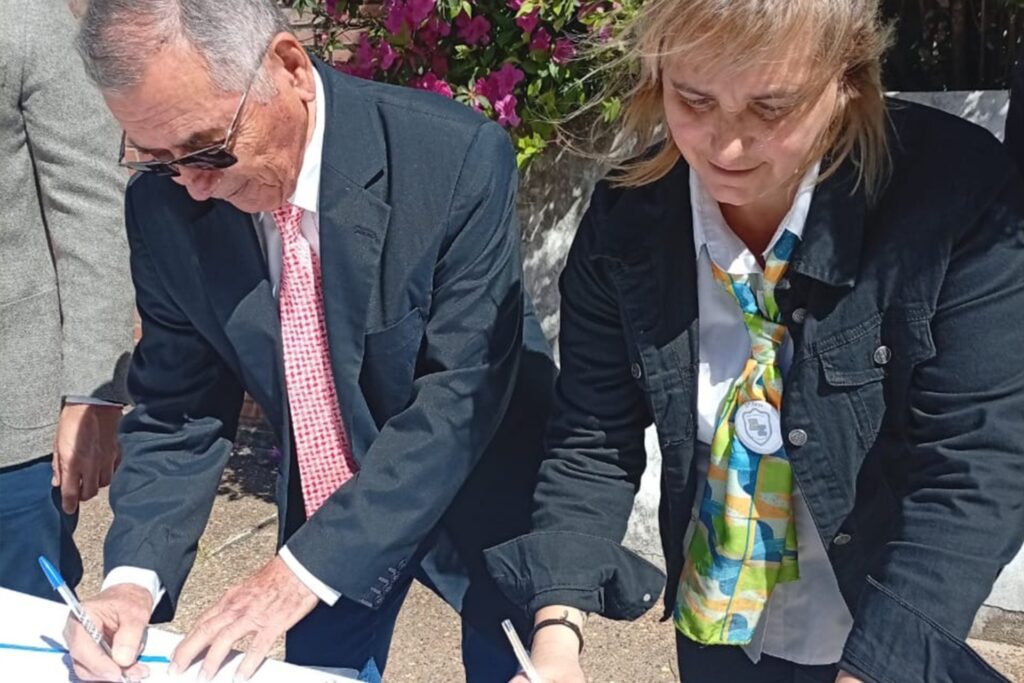 alt="El presidente de Cafesg, Carlos Cecco, y la rectora de la escuela Zorraquín, de Concordia, María Verónica Rodríguez, firrman el acta de recepción de la obra de refacción"