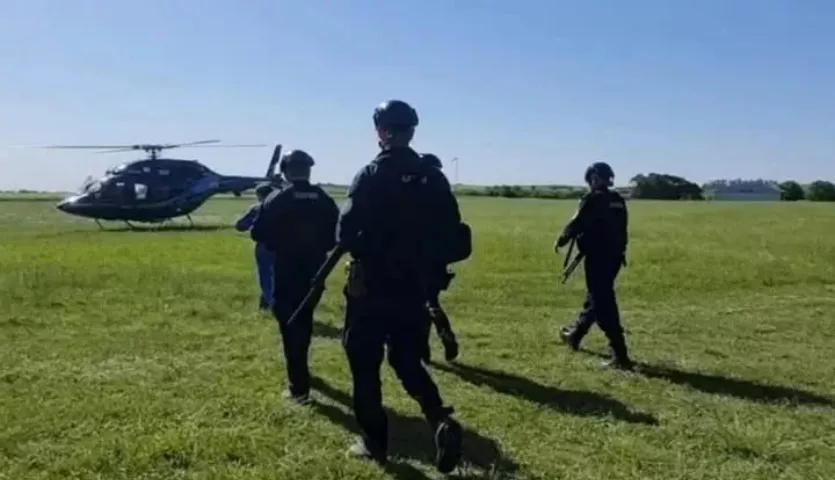 alt="integrantes de la policía entrerriana caminan hacia un helicóptero"