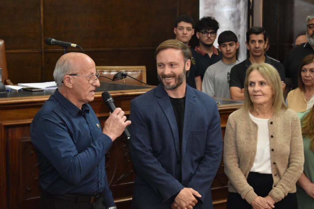 alt="El Maestro Miguel Ángel Paccot, 8° Dan de Taekwondo ITF, Vicepresidente de ATRA, Suboficial Principal (R) del Ejército Argentino, instructor de defensa personal y tiro deportivo, habla en presencia del intendente Francisco Azcué y la viceintendente Reta de Urquiza"